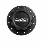 A black anodized aluminum fuel cell cap with a white and black PMR logo in the center and pre-drilled bolt holes around the outer rim, shown on a white background.