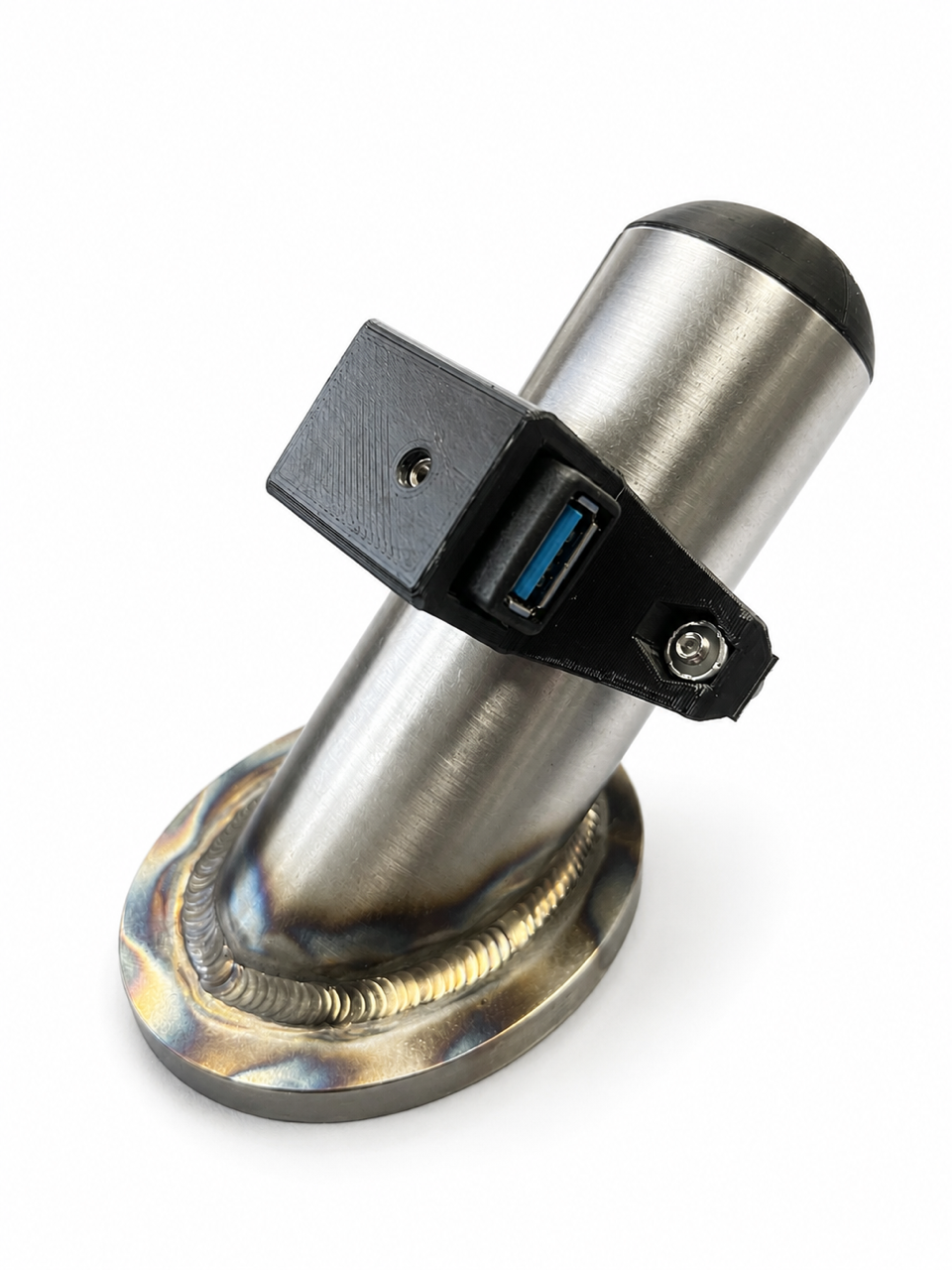 A brushed stainless steel cylindrical object with a black cap and a black mounting bracket attached, featuring a blue USB-C port on the side. The base is a custom welded oval flange with a blue heat-tinted finish, shown on a white background.